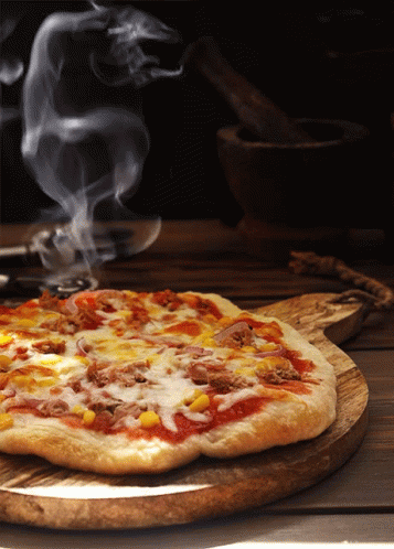 Parująca, świeżo upieczona pizza na drewnianej desce