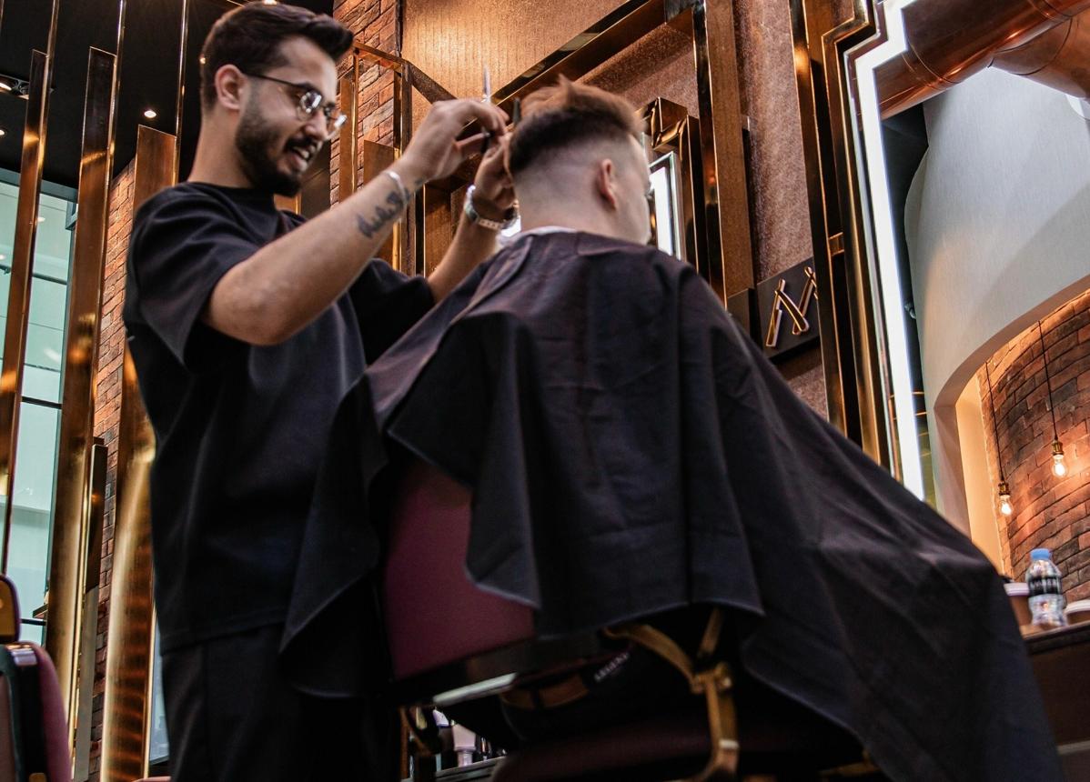 Barber i klient podczas przyjaznej rozmowy w trakcie strzyżenia